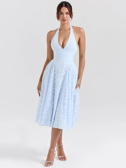 Woman wearing a Midi Dress in baby blue, showcasing the halter neck strap and soft A-line silhouette.