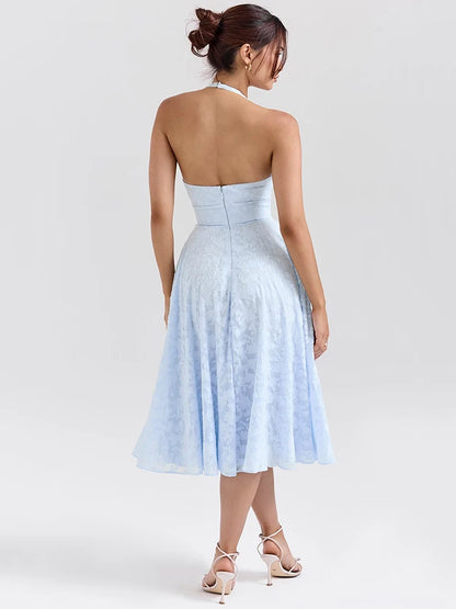 Woman wearing a Midi Dress in baby blue, showcasing the halter neck strap and soft A-line silhouette.