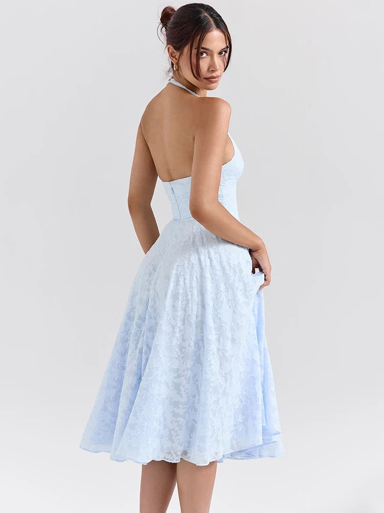 Woman wearing a Midi Dress in baby blue, showcasing the halter neck strap and soft A-line silhouette.