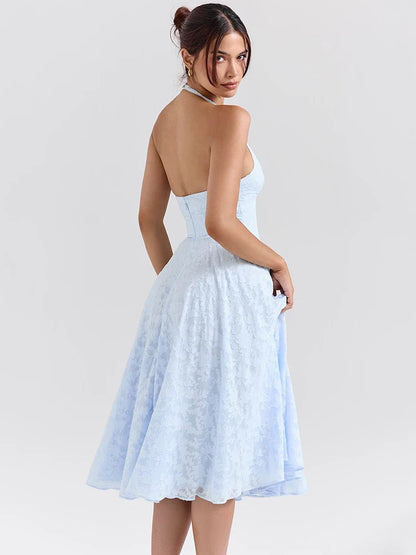 Woman wearing a Midi Dress in baby blue, showcasing the halter neck strap and soft A-line silhouette.