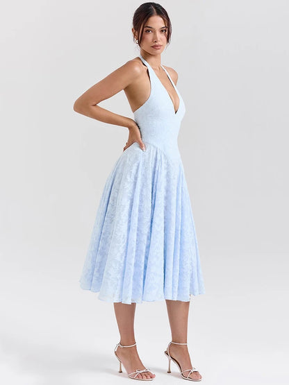 Woman wearing a Midi Dress in baby blue, showcasing the halter neck strap and soft A-line silhouette.