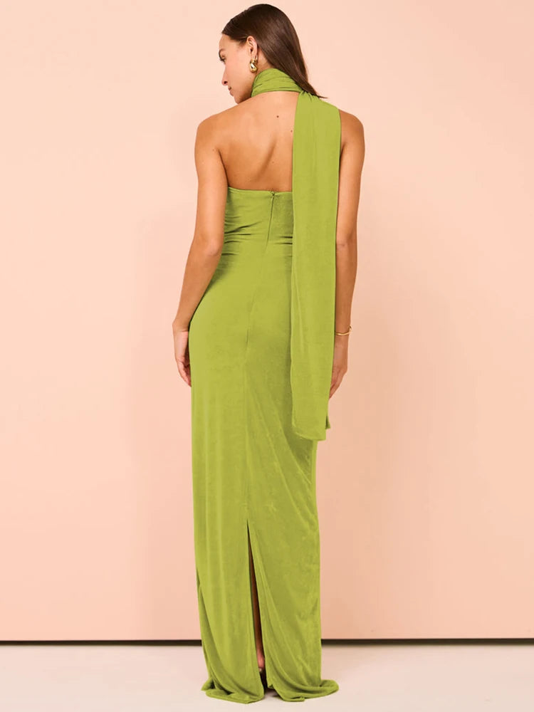 Woman wearing a green halter backless maxi dress for women in a sleek bodycon silhouette, sleeveless with a stylish, form-fitting design