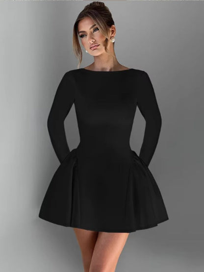 Woman wearing a black long-sleeved mini dress with an O-neck, high-waist A-line silhouette, bodycon fit, and a flowy skirt,