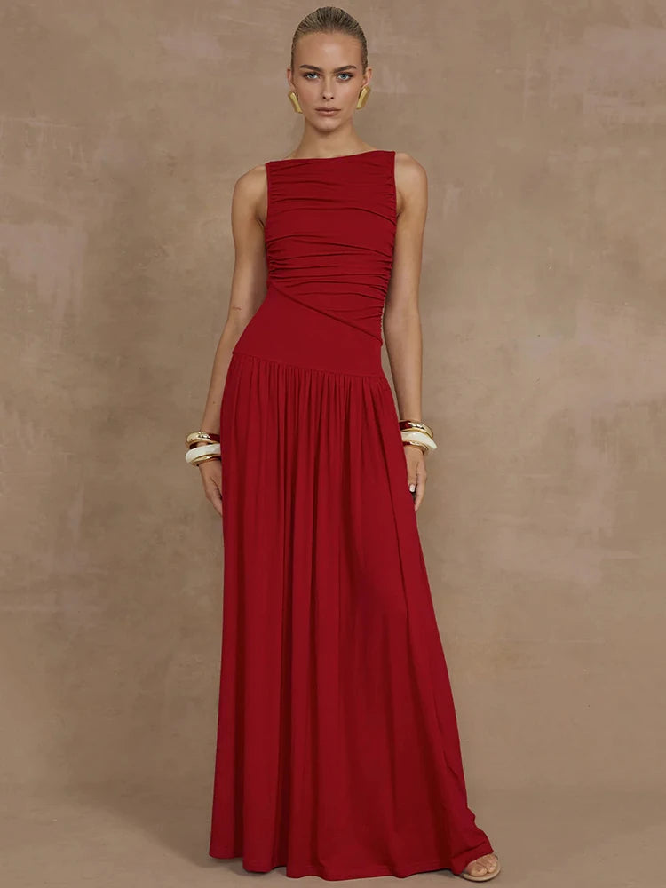 Woman wearing a sleeveless red maxi dress with a boat neck design, ruched detailing, and long, flowy silhouette