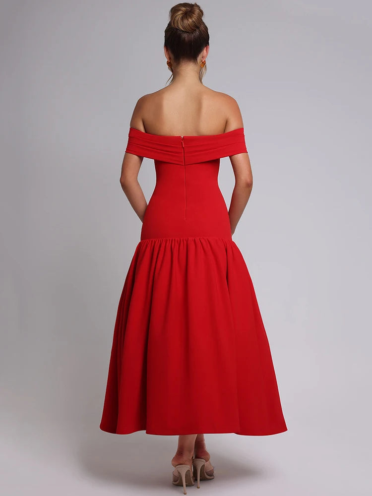 Woman wearing a red midaxi dress with a dropped waist, full gathered skirt, and pleated Bardot neckline, showcasing an elegant off-shoulder design