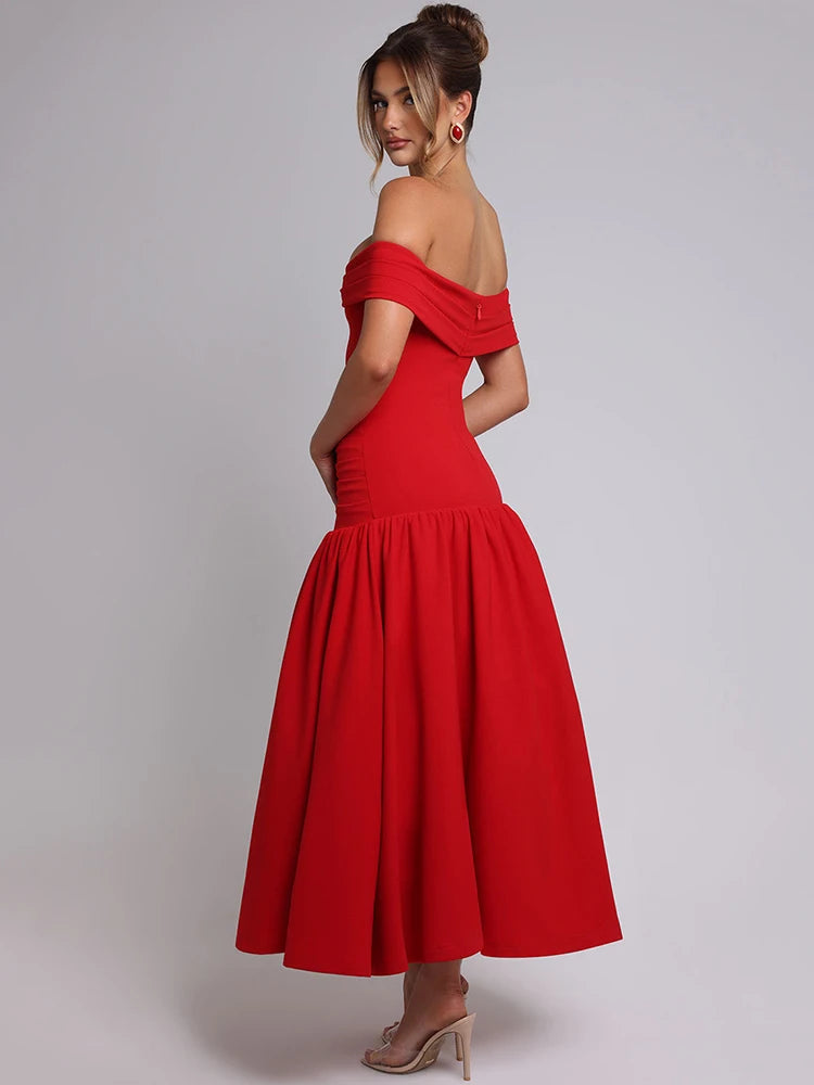 Woman wearing a red midaxi dress with a dropped waist, full gathered skirt, and pleated Bardot neckline, showcasing an elegant off-shoulder design