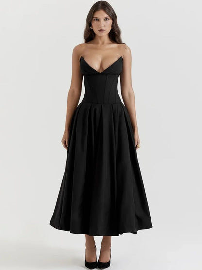 Woman wearing a black corset V-neck sleeveless maxi dress with chest-wrapping detail, high waist A-line skirt, fit and flare silhouette, and ankle-length design