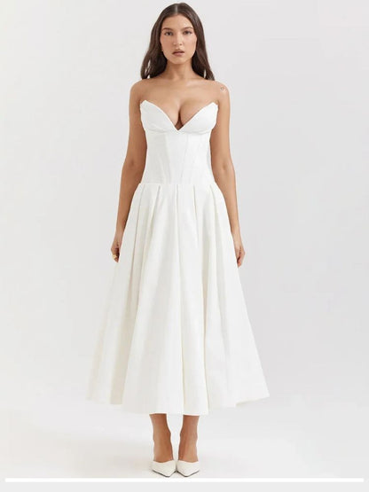 Woman wearing a white corset V-neck sleeveless maxi dress with chest-wrapping detail, high waist A-line skirt, fit and flare silhouette, and ankle-length design