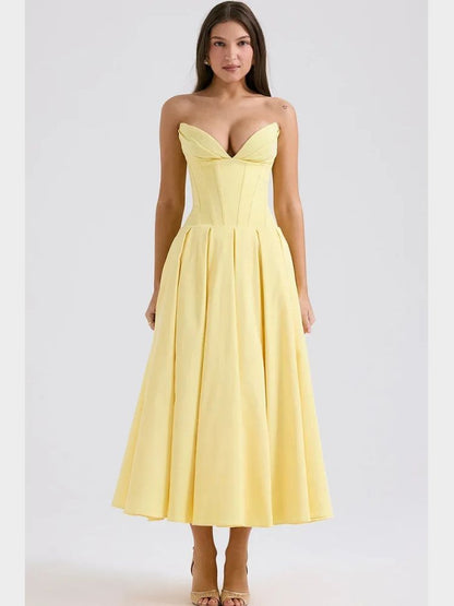 Woman wearing a yellow corset V-neck sleeveless maxi dress with chest-wrapping detail, high waist A-line skirt, fit and flare silhouette, and ankle-length design