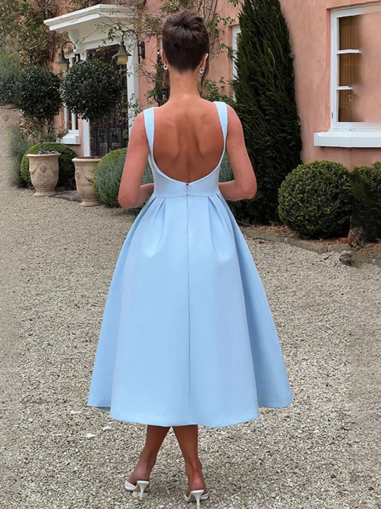 Woman wearing a light blue sleeveless Midi Dress with an A-line skirt, high boat neckline, V-shaped waist seam, low scoop back, and invisible zipper.