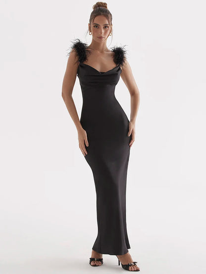 Woman wearing a Black satin maxi dress with feather spaghetti straps, sleeveless and backless design, bodycon fit