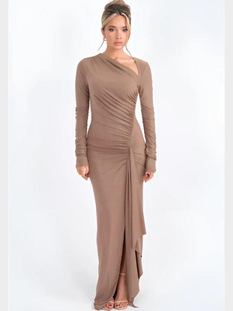 Woman wearing a sparkly beige asymmetrical maxi dress with long sleeves, ruched details, and a draped hemline.