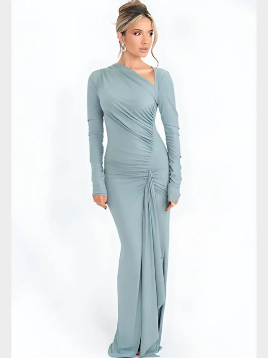 Woman wearing a sparkly light blue asymmetrical maxi dress with long sleeves, ruched details, and a draped hemline.