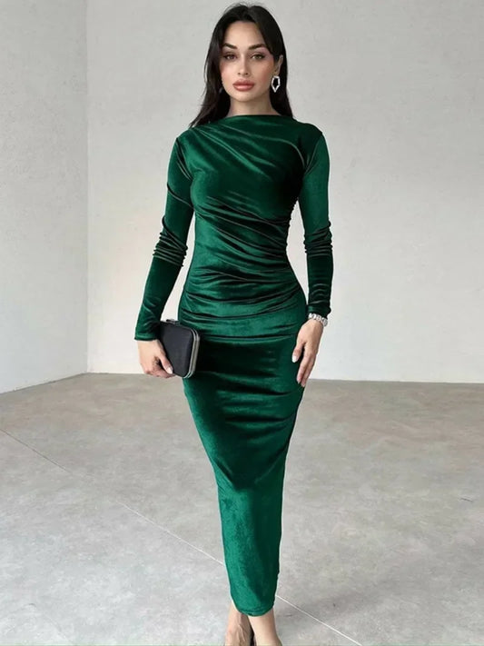 Woman wearing a green Midi Dress in velvet, featuring an O-neckline, long sleeves, high waist, and folded detailing with a mid-calf length 