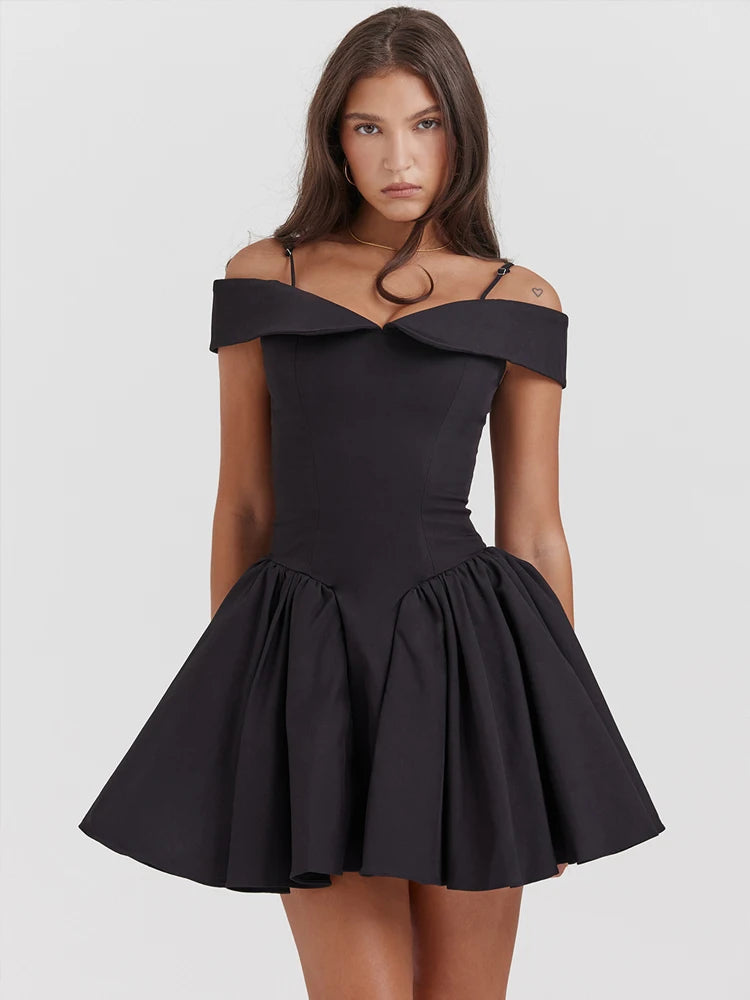 Woman wearing a Black A-line mini dress with a slash neckline, delicate straps, and a ruffle pleated skirt, offering a chic and feminine look