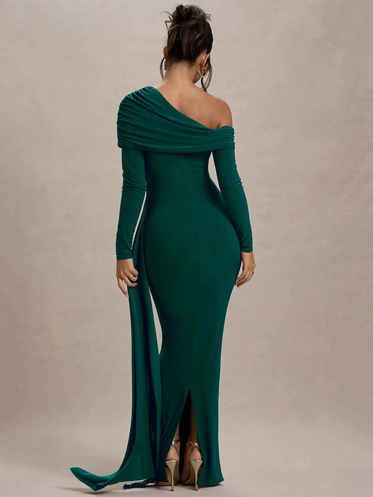 Woman wearing a dark green one-shoulder maxi dress with gathered detailing, draped sash, and a sleek, fitted silhouette