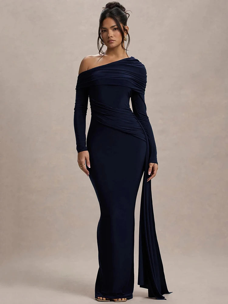 Woman wearing a navy blue one-shoulder maxi dress with gathered detailing, draped sash, and a sleek, fitted silhouette