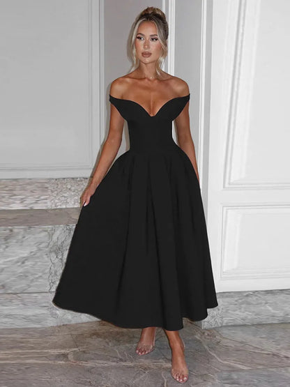 A woman wearing a Black off shoulder midaxi dress with a pleated skirt