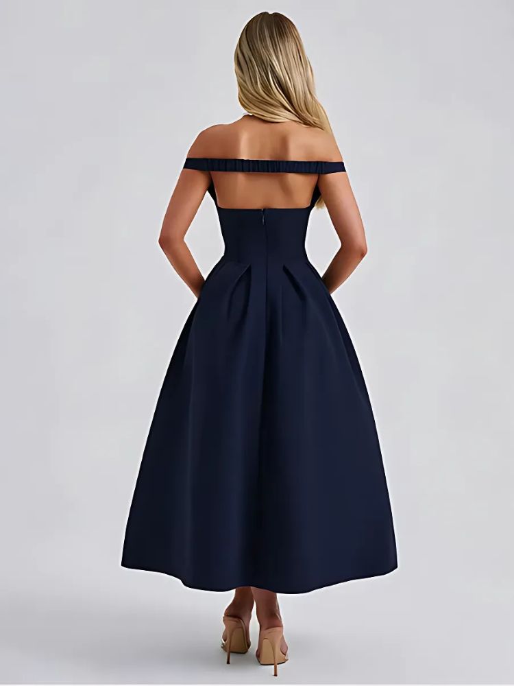 A woman wearing a navy off shoulder midaxi dress with a pleated skirt