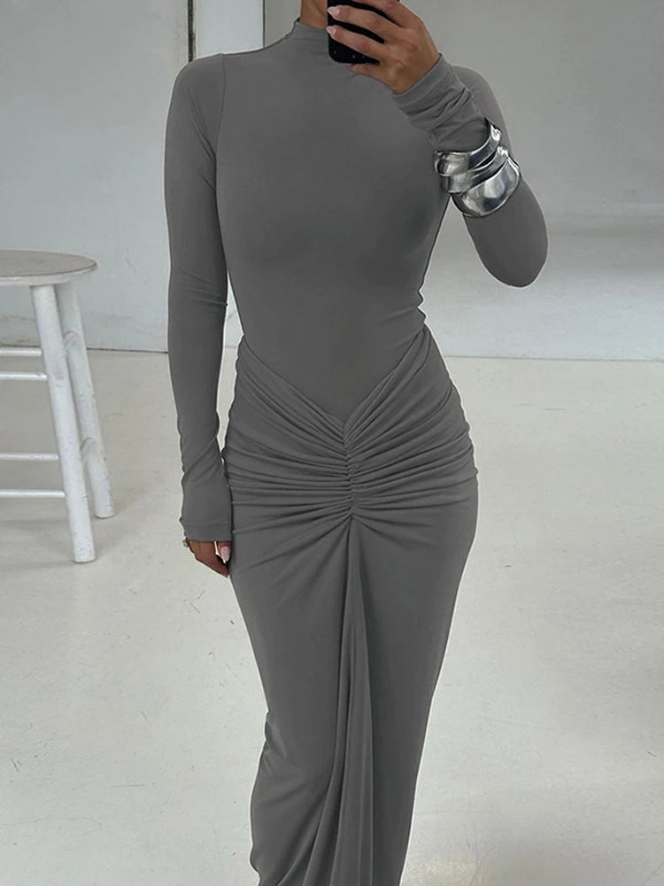 Woman wearing a Grey Floor-length bodycon dress with long sleeves, high collar, O-neck, high waist, pleated hip detail, and invisible zipper