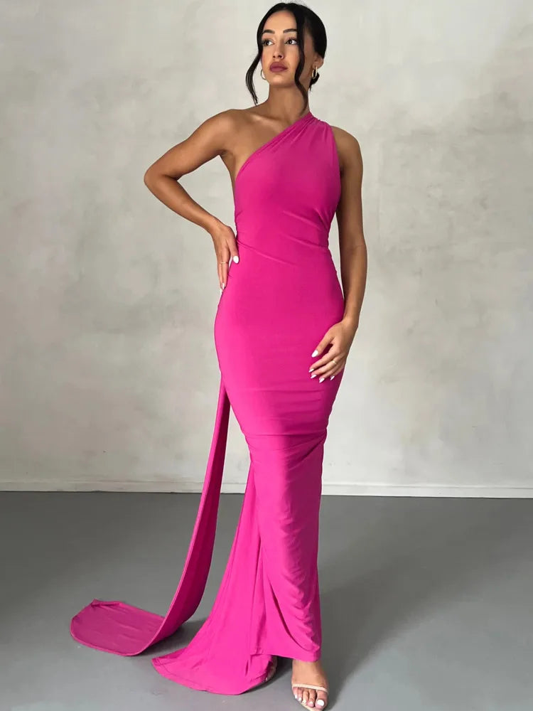 Pink bodycon maxi dress with a backless design, oblique shoulder, ruched detailing, and strap accents. Features a trumpet/mermaid silhouette, strapless neckline, and off-the-shoulder sleeves.