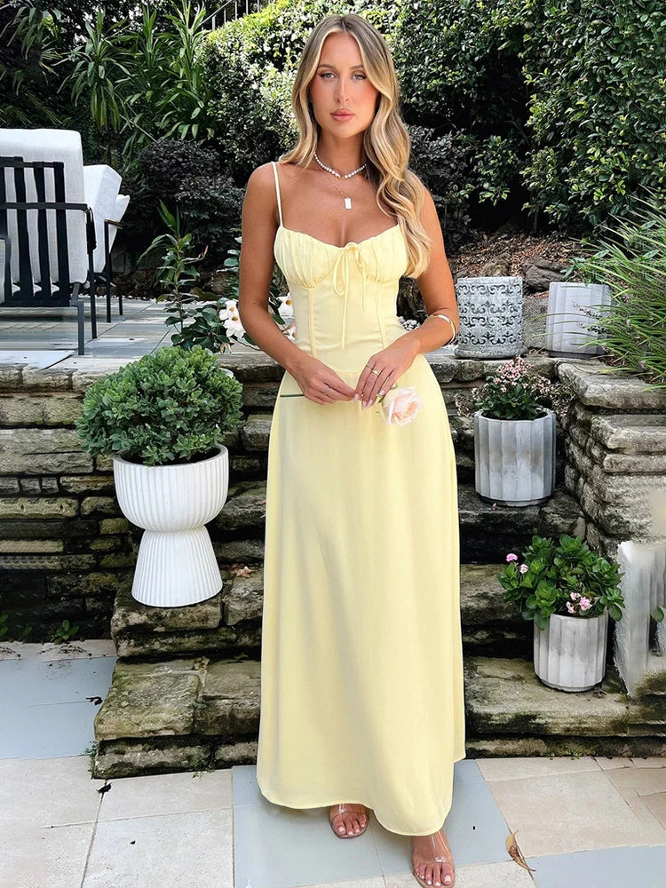 Yellow A-line maxi dress with a waist wrap design, slight stretch, and spaghetti straps. Features a strapless neckline, ankle-length fit, bow decoration, and pullover closure. Made from spandex and polyester.