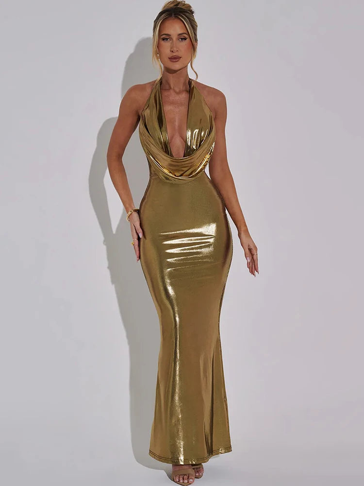 A woman wearing a gold colour bodycon maxi dress with a halter neck, deep V-neck, sleeveless and backless design. The dress has a sleek, form-fitting silhouette, ideal for making a bold and glamorous statement at special events.