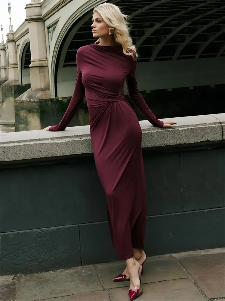 Woman wearing a burgundy maxi dress with long sleeve, pleated, O-neck, ankle-length  and stretchy fabric